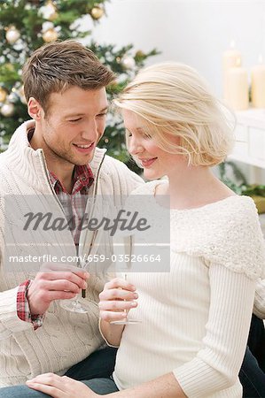 Man & woman clinking glasses of sparkling wine (Christmas)