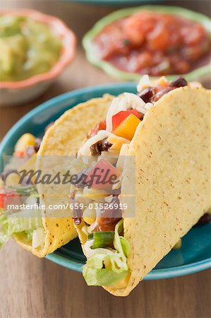 Vegetable tacos, dips in background (Mexico)