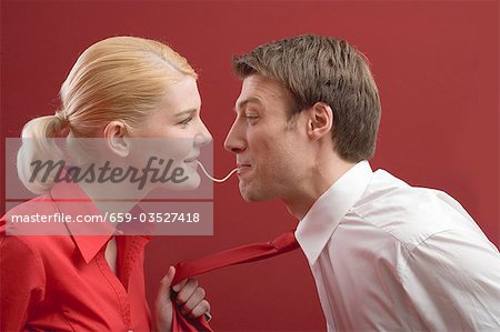 Couple eating a strand of spaghetti from both ends