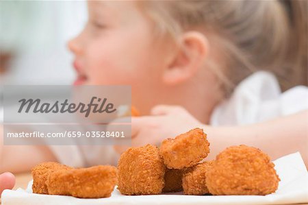 Little girl eating chicken nuggets