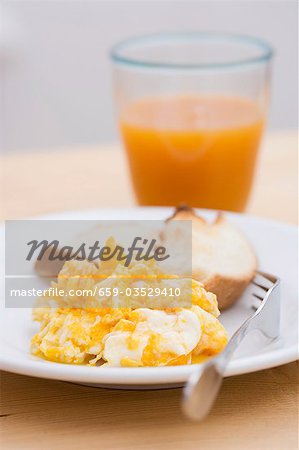 Scrambled egg, toast and glass of fruit juice