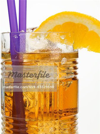 Rum drink with ice cubes and orange wedge Rum drink with ice cubes and orange wedge