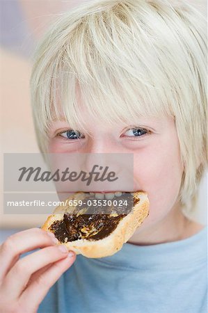 Boy eating Vegemite on toast (Australia)