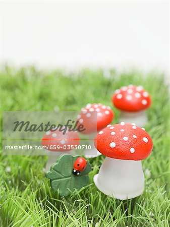 Lucky charms (fly agaric mushrooms, 4-leaf clover) in grass