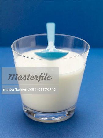 Yoghurt in glass with plastic spoon