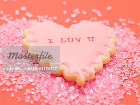 Heart-shaped biscuit on pink sugar