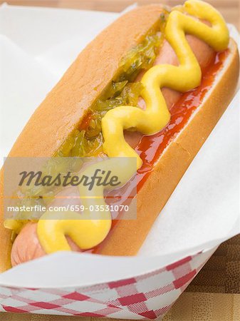 A hot dog with mustard, onion relish and ketchup