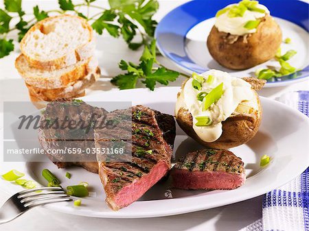 Grilled rump steak with baked potato and sour cream