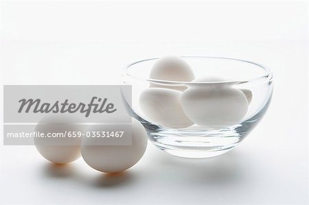 White Eggs in and Beside a Glass Bowl