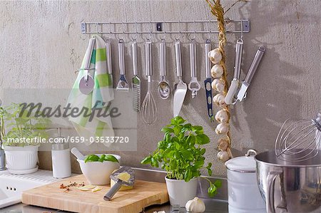 Kitchen utensils, string of garlic, basil, Parmesan etc.