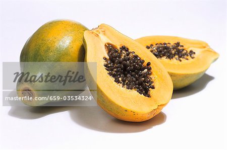 Papayas, one whole and one halved
