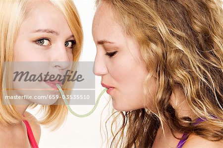 Two women eating a sour snake