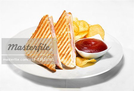 Toasted ham and cheese sandwiches with ketchup and crisps