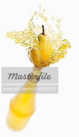 Pear juice splashing out of bottle