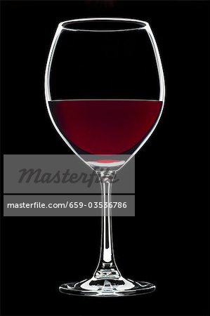 Glass of red wine against black background