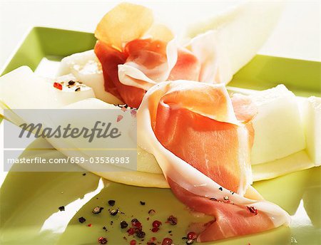 Prosciutto and melon sprinkled with pink pepper