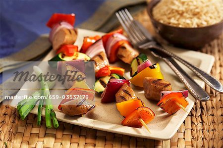 Grilled Sausage and Vegetable Kabobs on a Plate; Knife and Fork