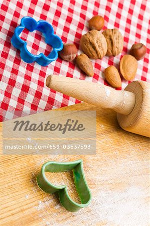 Rolling pin, biscuit cutters and nuts with wooden board