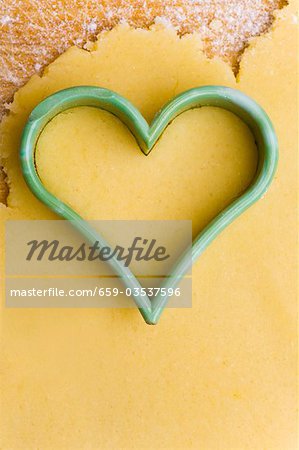 Heart-shaped cutter on biscuit dough