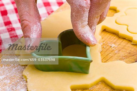 Cutting out a biscuit with a heart-shaped cutter