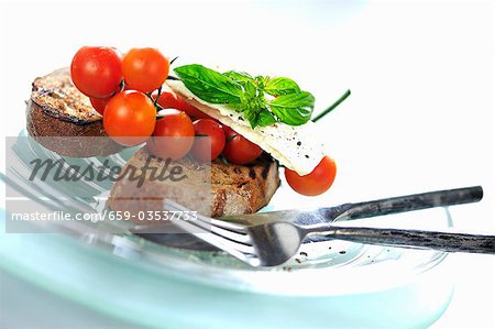 Toast with cherry tomatoes, feta cheese and basil