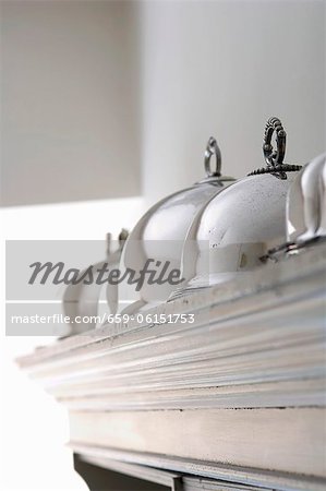 Silver cloches on top of a cupboard Silver cloches on top of a cupboard