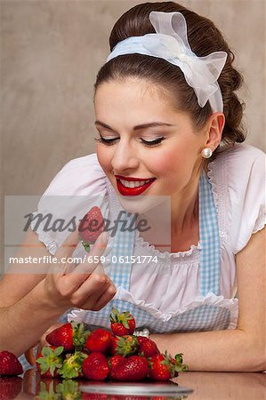 A retro-style girl eating fresh strawberries