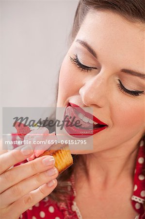 A girl eating a strawberry muffin A girl eating a strawberry muffin