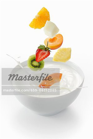 Fresh fruit falling into a bowl of yogurt