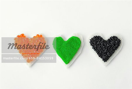 Three heart-shaped canapes with colourful caviar