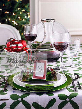 A table laid in green and white for Christmas with red wine