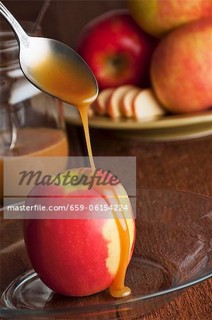 Caramel Sauce Pouring Over an Organic Pink Lady Apple