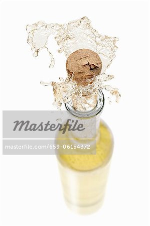 White wine spraying out of a bottle