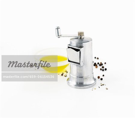 Pepper grinder, peppercorns and olive oil
