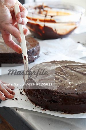 Chocolate glaze being spread onto a cake Chocolate glaze being spread onto a cake