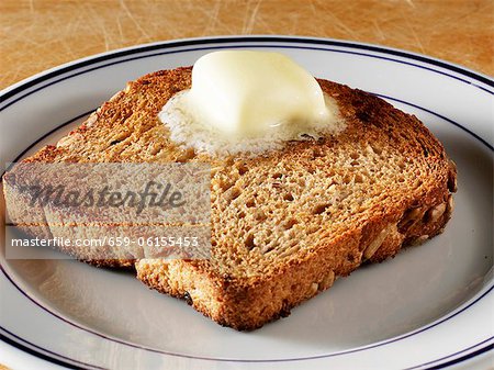 Pat of Butter Melting on a Piece of Whole Grain Toast