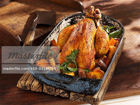 Roast chicken with root vegetables in an old roasting pan