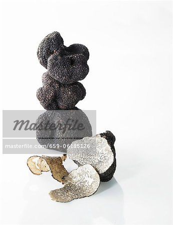 Black truffles, stacked, one partly sliced