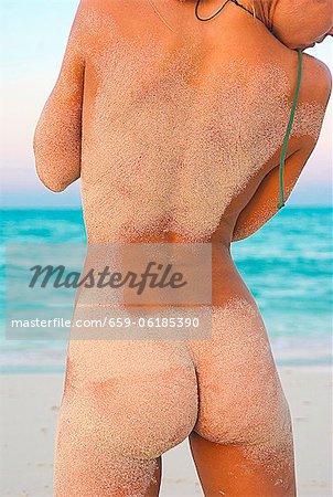 Back view of a naked woman on a sandy … – License Images – 986723