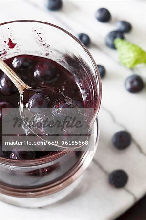 Homemade Blueberry Compote in a Spoon Above a Jar