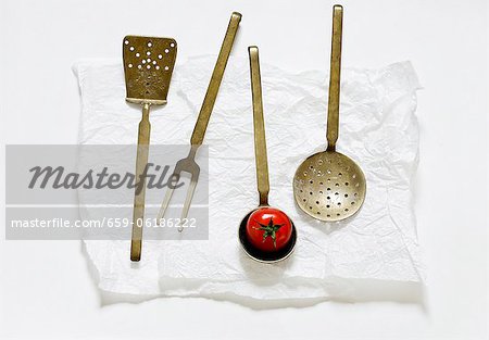 Various old kitchen utensils and a tomato