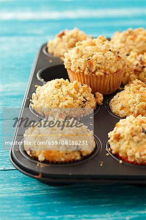 Apple muffins topped with nut crumble in a muffin tin