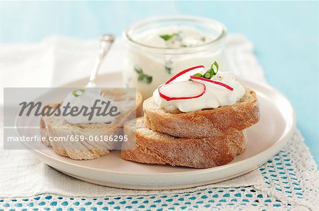 Slices of bread topped with chive quark and radishes Slices of bread topped with chive quark and radishes