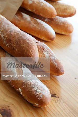 Several baguettes in paper bag