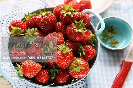 Strawberries in a colander on a crocheted doily