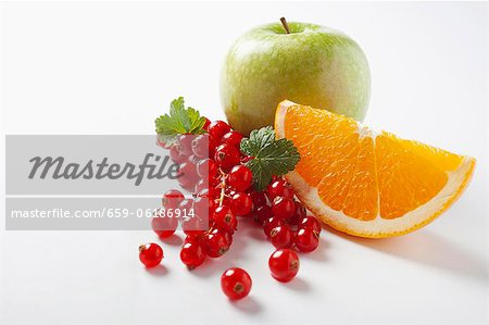 Redcurrants, an orange wedge and an apple