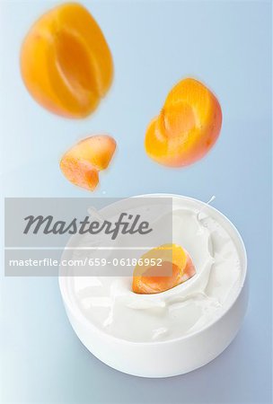 Peaches falling into yogurt