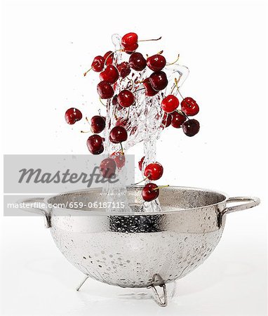 Cherries and a splash of water falling into a colander