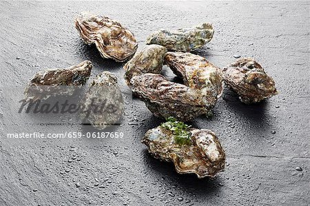 Several fresh oysters on slate