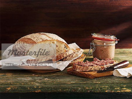 Cut rustic loaf and slice of bread with spread